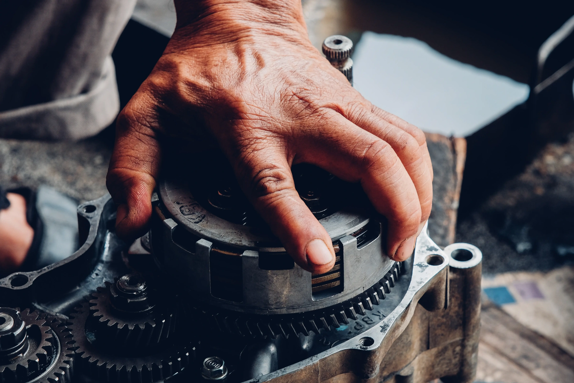 Illustrative close-up of hands working on a gearbox assembly